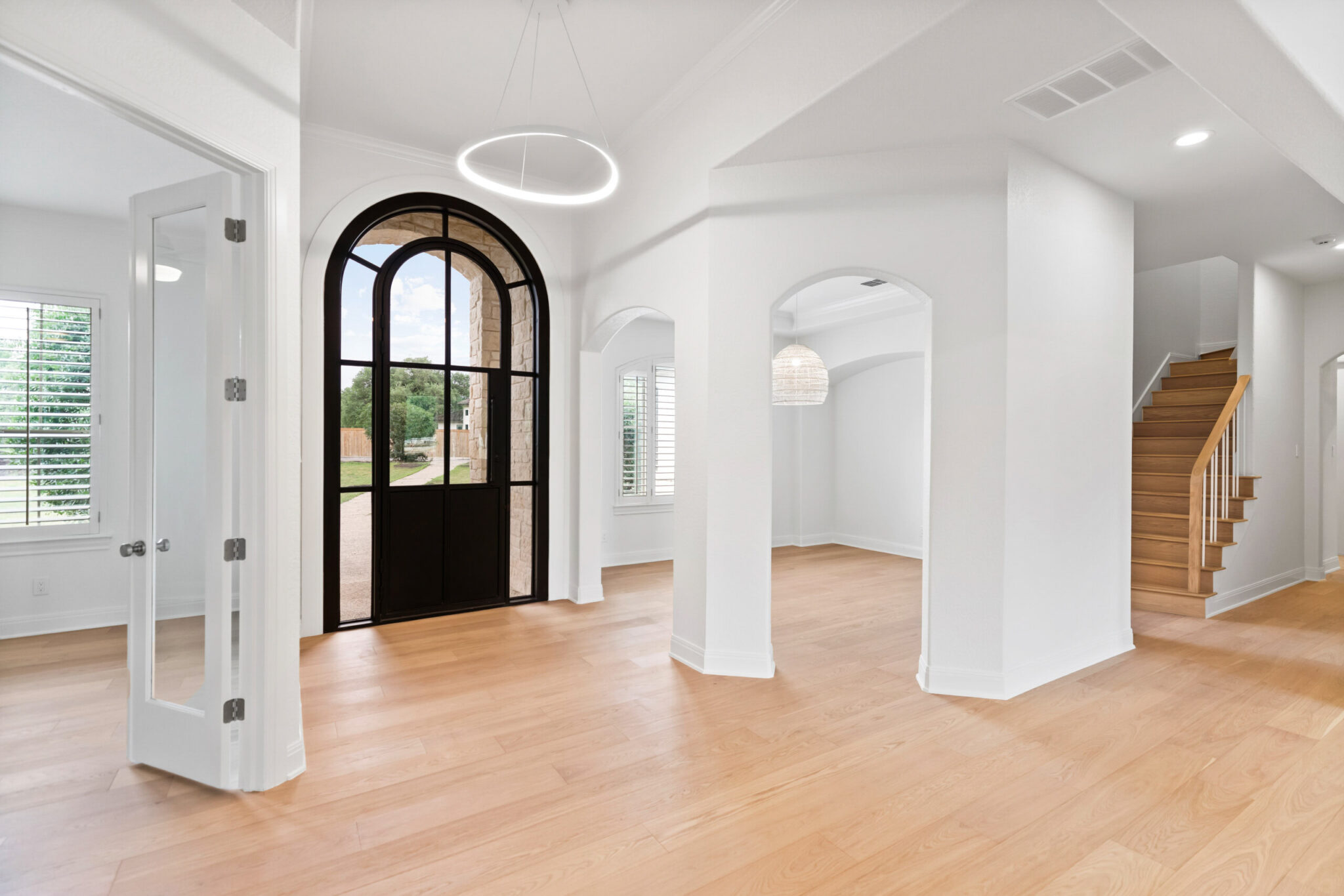 Remodeling in Fair Oaks Ranch | Texas Highlands Custom Homes & Remodel Updated living room with new finishes and large windows on a wooded lot